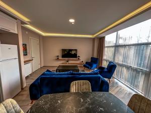 a living room with blue couches and a table at MY SUITE in Yalova