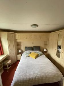1 dormitorio con cama blanca y almohada amarilla en Le Murmont, en Thonnance-lès-Joinville