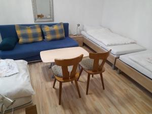 ein Wohnzimmer mit einem Sofa, einem Tisch und Stühlen in der Unterkunft Classic Appartments in Knittelfeld