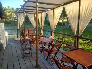 a group of tables and chairs on a patio at Casa de Praia, pé na areia Guaratiba Prado - Bahia in Prado