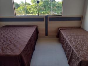 an empty room with two beds and a window at Casa de Praia, pé na areia Guaratiba Prado - Bahia in Prado +41 photos