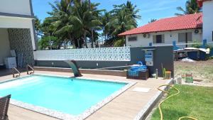 a swimming pool in a yard next to a house at Casa de Praia, pé na areia Guaratiba Prado - Bahia in Prado