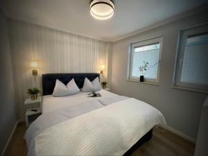 a bedroom with a large white bed with a window at Villa Am Meer Glowe Apartment EG in Glowe