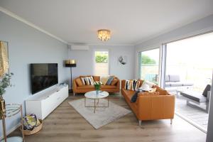 a living room with two couches and a tv at Villa Am Meer Glowe Apartment EG in Glowe