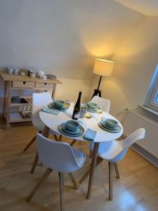 a white table with chairs and a bottle of wine on it at Modernes, familienfreundliches Apartment in Lübeck in Lübeck