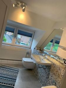 a bathroom with a sink and a toilet and a mirror at Modernes, familienfreundliches Apartment in Lübeck in Lübeck