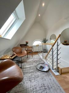 sala de estar con escalera, sillas y mesa en Modernes, familienfreundliches Apartment in Lübeck en Lübeck