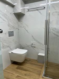 y baño blanco con aseo y ducha. en NAFPAKTOS-luxury suite en Nafpaktos