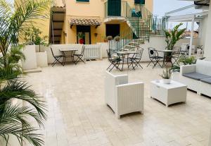eine Terrasse mit Stühlen, Tischen und einer Treppe in der Unterkunft Bed and Breakfast Arco dei cappuccini in Taormina