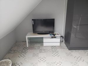 a tv sitting on top of a white table at Ile Cigogne in Fouesnant