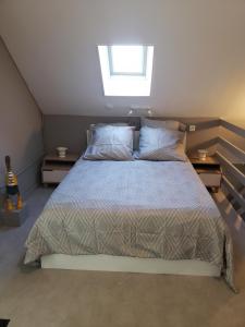 a bedroom with a large bed with a window at Ile Cigogne in Fouesnant