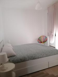 a white bedroom with a bed and a window at LoVe House - Apartment on the beach in Pescara