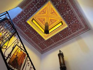 um quarto com um tecto com uma pintura em Riad Hugo em Marrakech