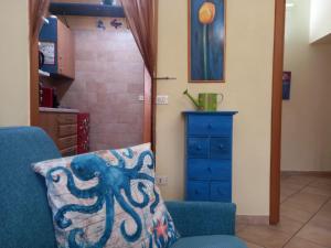 almohada de pulpo en una silla azul en una habitación en Pozzuoli 100per100 Home, en Pozzuoli