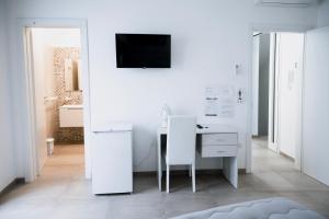 un ufficio bianco con scrivania e TV a parete di Bed and Breakfest Terra d'Arneo a Leverano