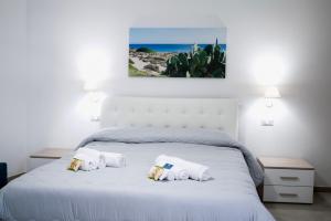 una camera da letto con un letto bianco e asciugamani di Bed and Breakfest Terra d'Arneo a Leverano