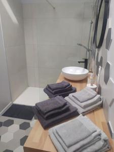 uma casa de banho com um lavatório e quatro toalhas numa mesa em Pied à terre familial au pied du Luberon em Mérindol