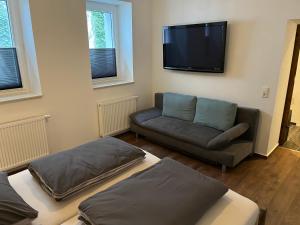 a living room with a couch and a flat screen tv at Ferienwohnungen am Markt - Der Sachsenhof in Bad Liebenwerda
