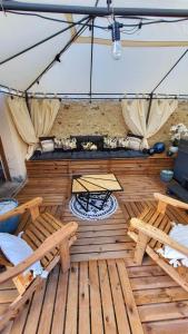 a wooden deck with a table and benches on it at Gîte au cœur des vignes avec piscine et spa in Saudoy