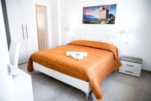 a bedroom with a bed with an orange blanket at Bed & Breakfast Terra d'Arneo in Leverano