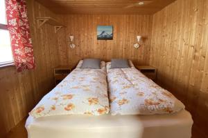 Bett in einem Zimmer mit zwei Kissen darauf in der Unterkunft Sudur-Bár Guesthouse in Grundarfjörður