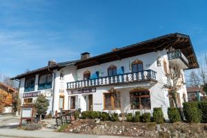 Großes weißes Gebäude mit Balkon in der Unterkunft Hotel Bavaria in Inzell