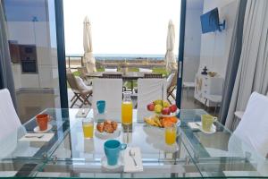 a glass table with a bowl of fruit and orange juice at Luxury Villa Punta Mujeres in Punta Mujeres