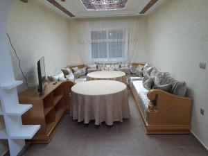 ナドールにあるappartement NADOR wifi gratuitのリビングルーム(ソファ、テーブル、テレビ付)