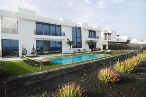 a large white house with a swimming pool at Luxury Villa Punta Mujeres in Punta de Mujeres