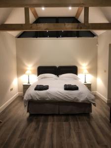 um quarto com uma cama grande e 2 candeeiros em 2 mesas em The Stables em Colchester