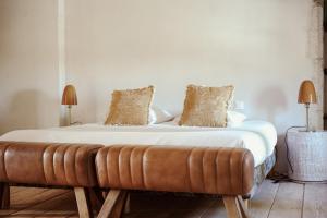 - un lit avec un banc en cuir dans une pièce dans l'établissement Château de La Vallade, à Saint-Porchaire