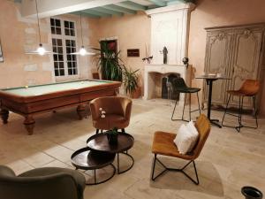 a living room with a pool table and chairs at Château de La Vallade in Saint-Porchaire
