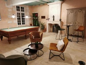 - un salon avec une table de billard et des chaises dans l'établissement Château de La Vallade, à Saint-Porchaire