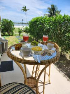 una mesa con comida y copas de vino en un patio en Golden Lake - Vista Lagoa, en Arraial do Cabo