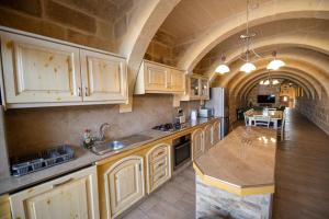 a kitchen with white cabinets and a counter top at Ta' Rozi 5 Bedroom Farmhouse with Private Pool in Għarb
