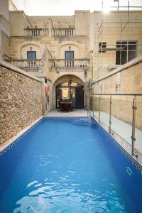 a large blue swimming pool in a building at Ta' Rozi 5 Bedroom Farmhouse with Private Pool in Għarb