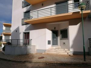 a white building with stairs and a balcony at AL - Amar Odeceixe in Odeceixe