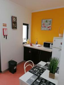 a kitchen with a counter and a refrigerator and a table at AL - Amar Odeceixe in Odeceixe +3 photos