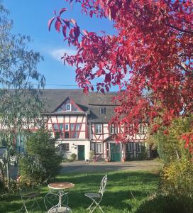 una casa con foglie rosse su un cortile con tavolo e sedie di Hof Idarwald a Horbruch