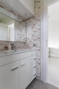 a white bathroom with a sink and a mirror at Golf View Apartment - stunning ocean view Golf del Sur in San Miguel de Abona