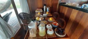 a table with breakfast food on it in a room at Ventos do Delta Kite Chalés in Tutóia