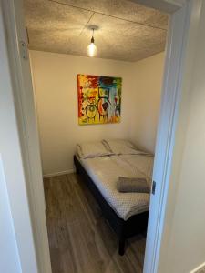 un letto in una stanza con un dipinto sul muro di RE-Seapark a Hvidovre