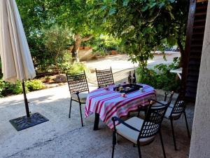 a table with chairs and an umbrella on a patio at Villa Agava in Vrboska