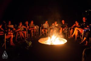 Un groupe de gens assis autour d'un feu dans l'établissement Lodg'ing Nature Camp Dordogne, à Lacave