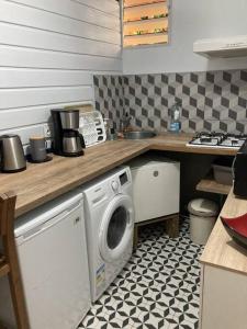 una cucina con lavatrice di Agréable logement, bien situé a Schœlcher