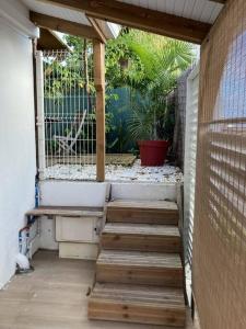 a porch with stairs and a window with a fence at Agréable logement, bien situé in Schœlcher