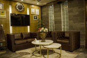 ダッカにあるHotel Shuktara Dhakaの革張りのソファとテレビが備わる待合室
