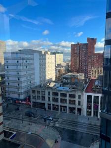 a view of a city with tall buildings and cars at Brand new heart of Birmingham one bedroom in Birmingham +10 photos