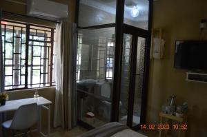 1 dormitorio con puerta corredera de cristal y ventana en Glorious Home Bed & Breakfast en Mochudi