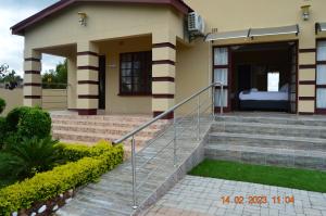 a house with a staircase leading to the front door at Glorious Home Bed & Breakfast in Mochudi